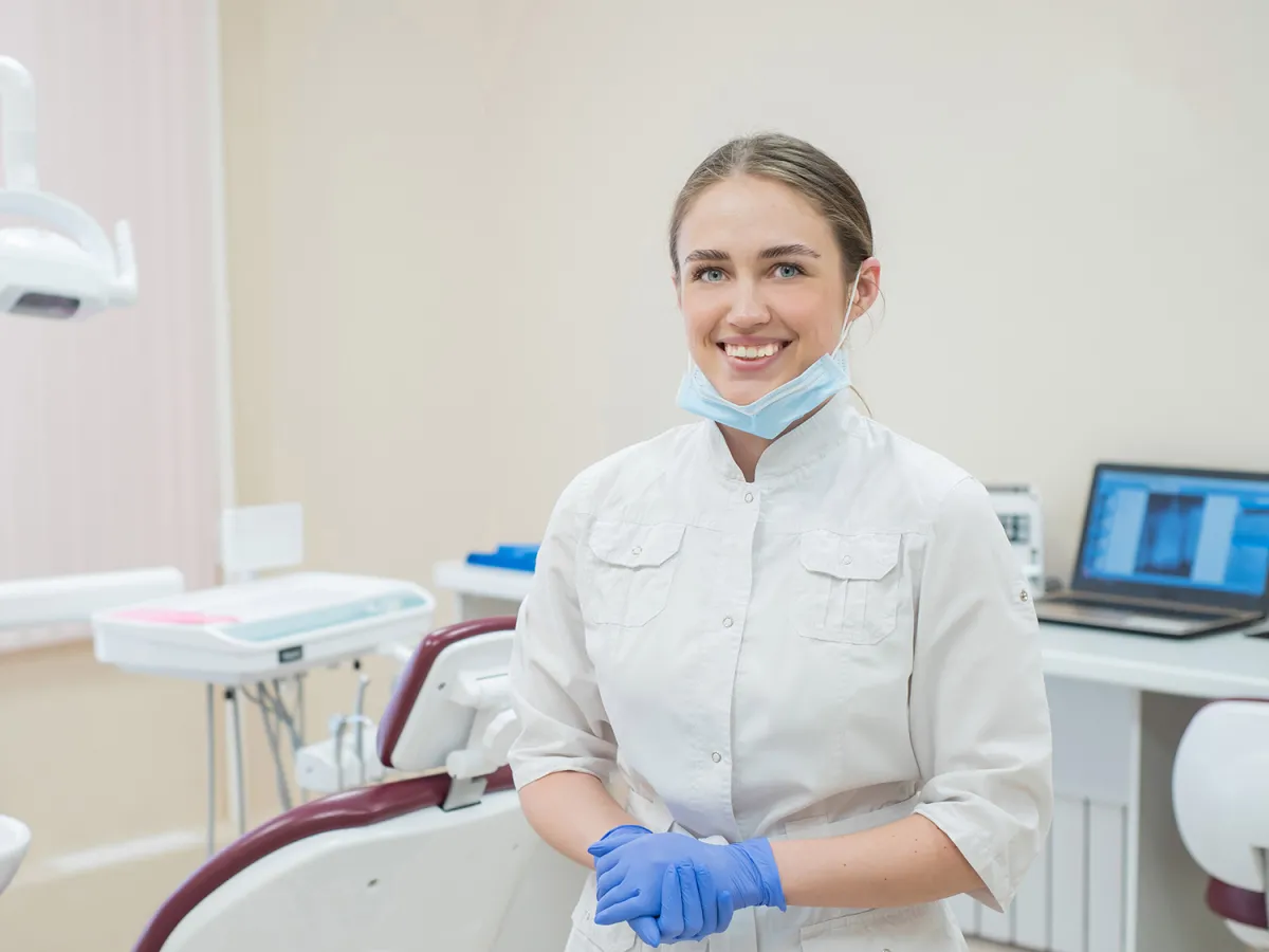 female dentist smiling by chair