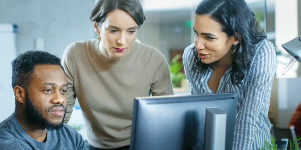 people talking around a computer