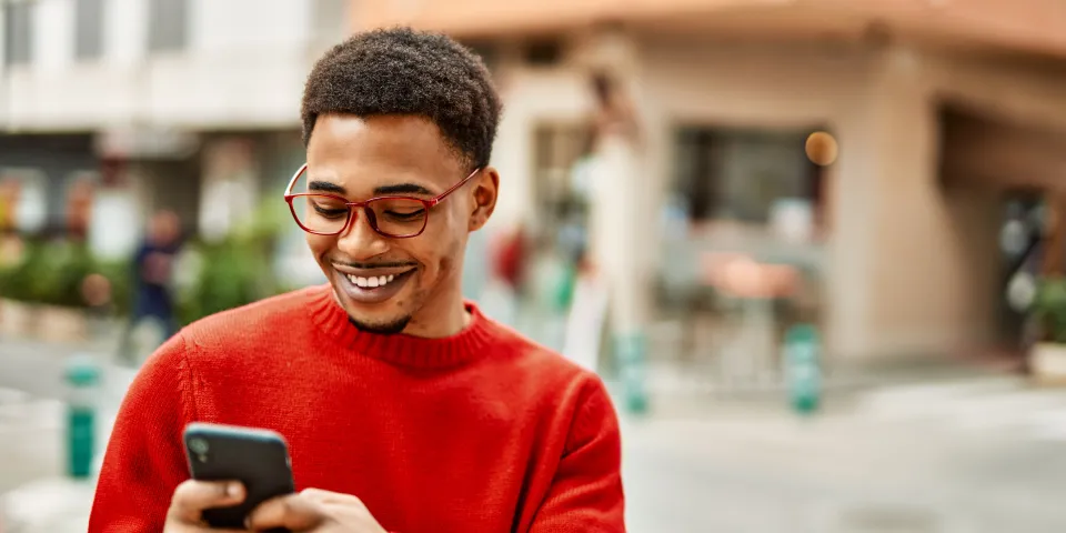 man on phone wearing glasses smiling